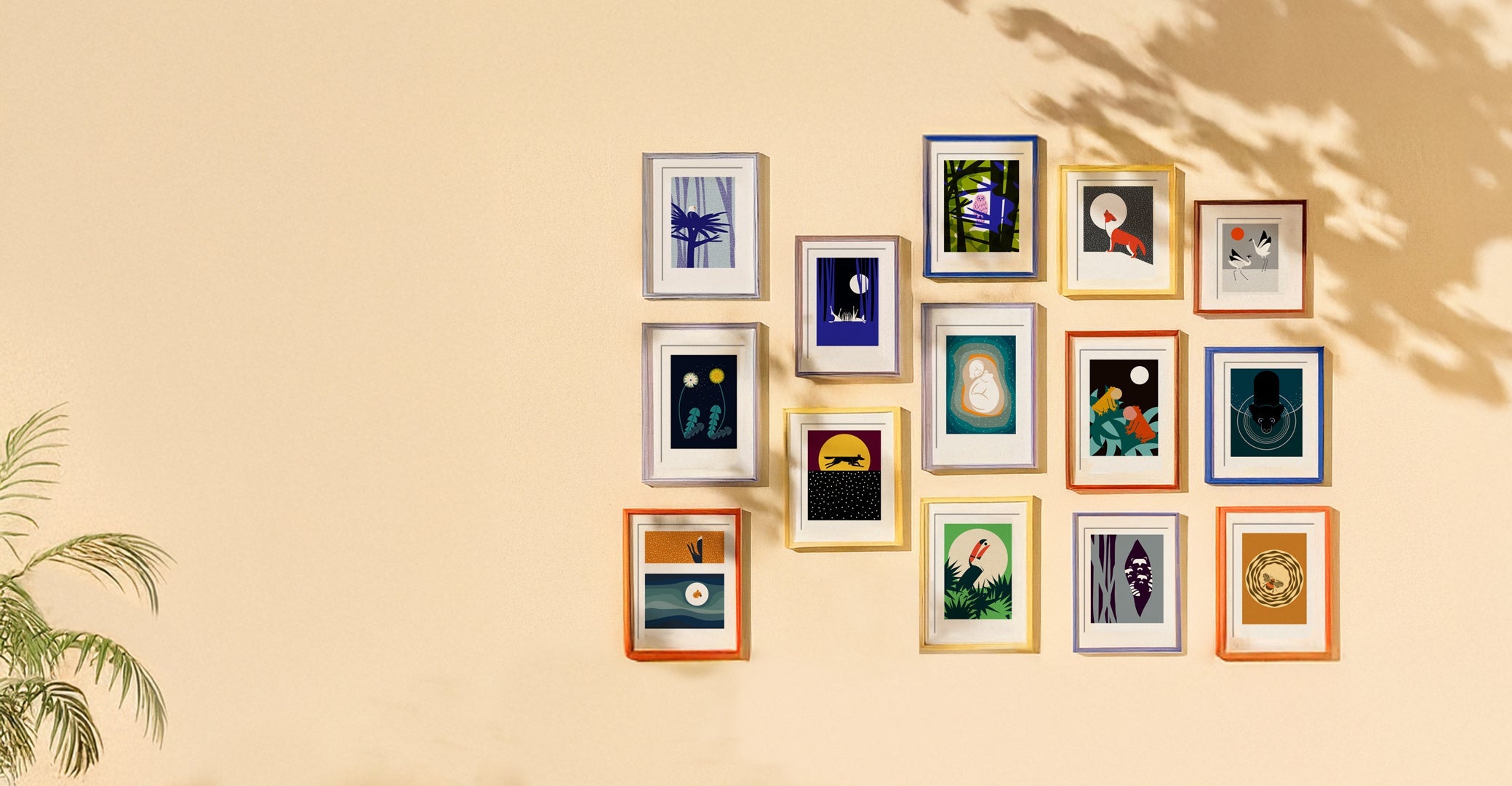 Multiple, multi-coloured frames featuring art prints by Gentle Knight Designs, hanging on a cream coloured wall.
